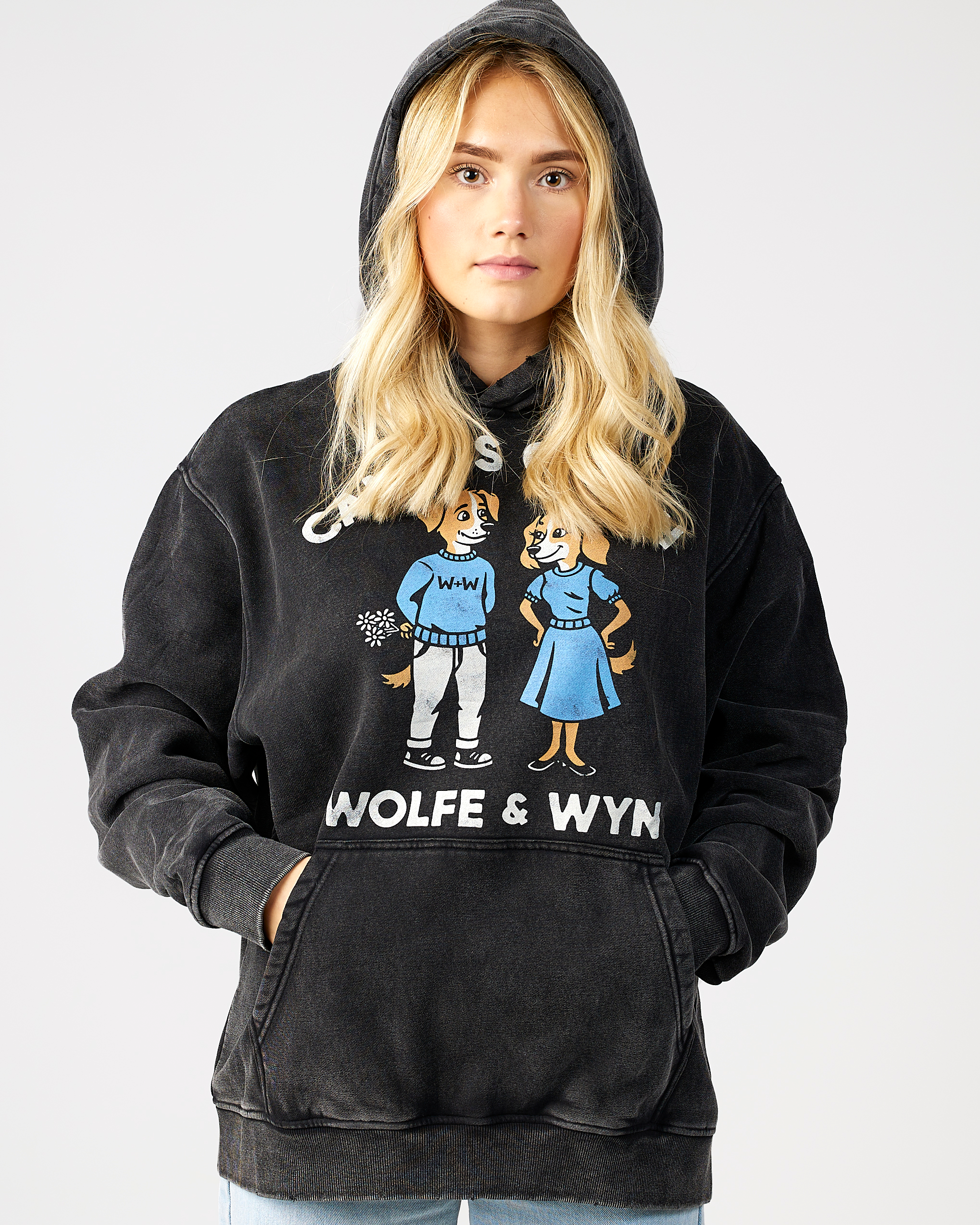 model wearing a black hoodie with 'Wolfe & Wyn' design on a plain background