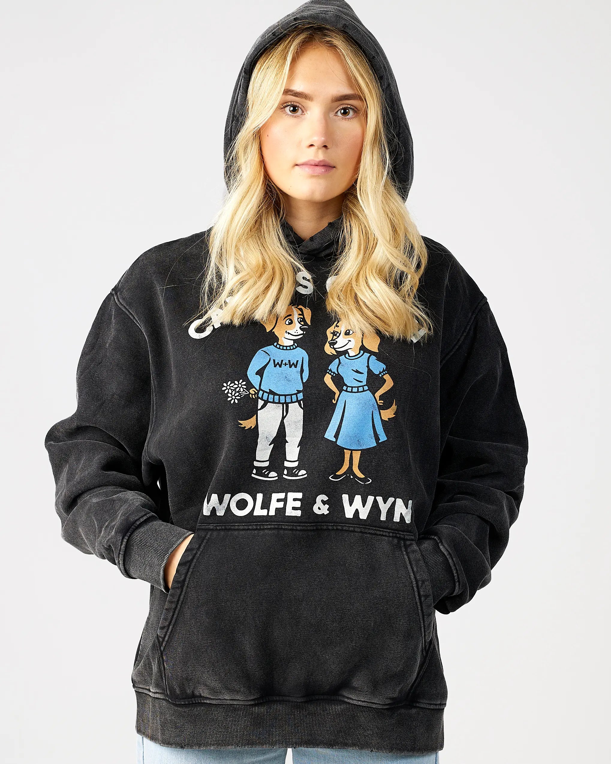 Person wearing a black hoodie with 'Wolfe & Wyn' design on a plain background
