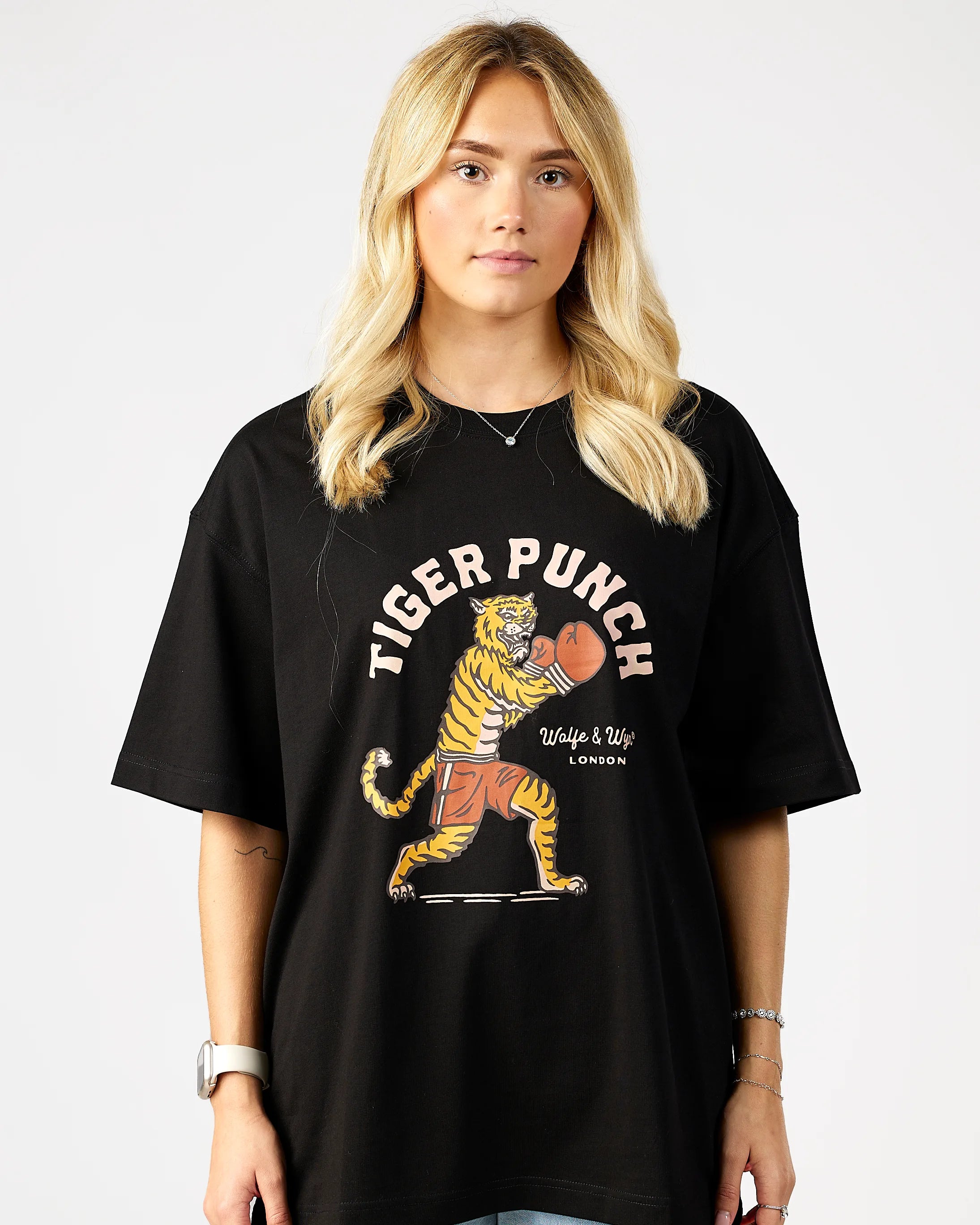 Person wearing a black t-shirt with a tiger graphic and 'Tiger Punch' text on a plain background