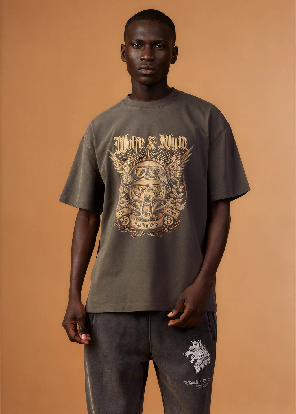 Man wearing a green t-shirt with a graphic design on a brown background