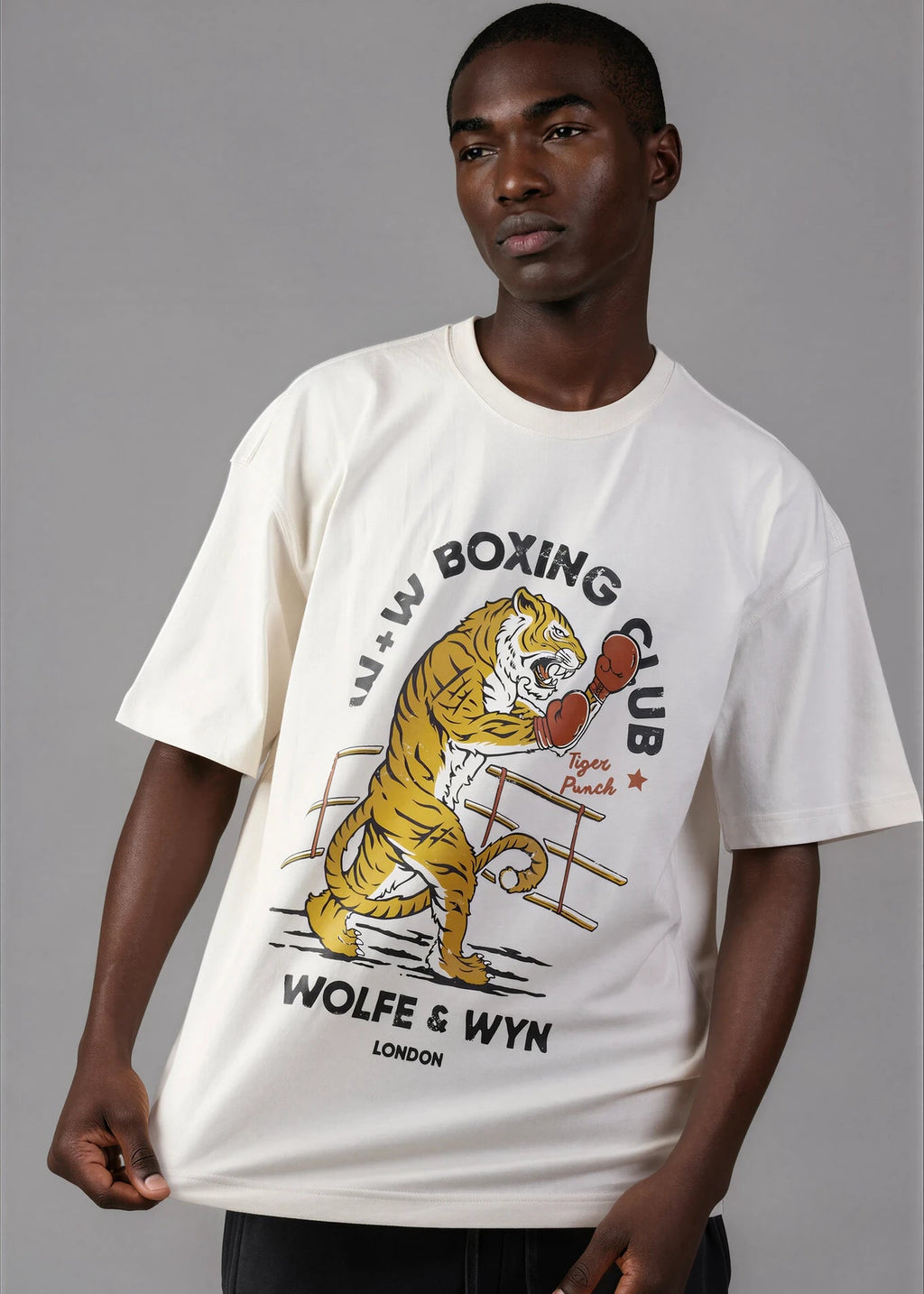 Man wearing a white t-shirt with a tiger graphic and text on a gray background