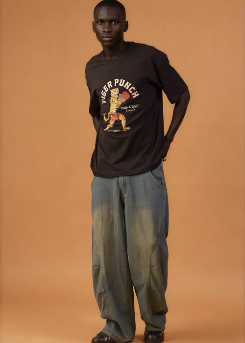 Person wearing a black t-shirt with a graphic design on an orange background