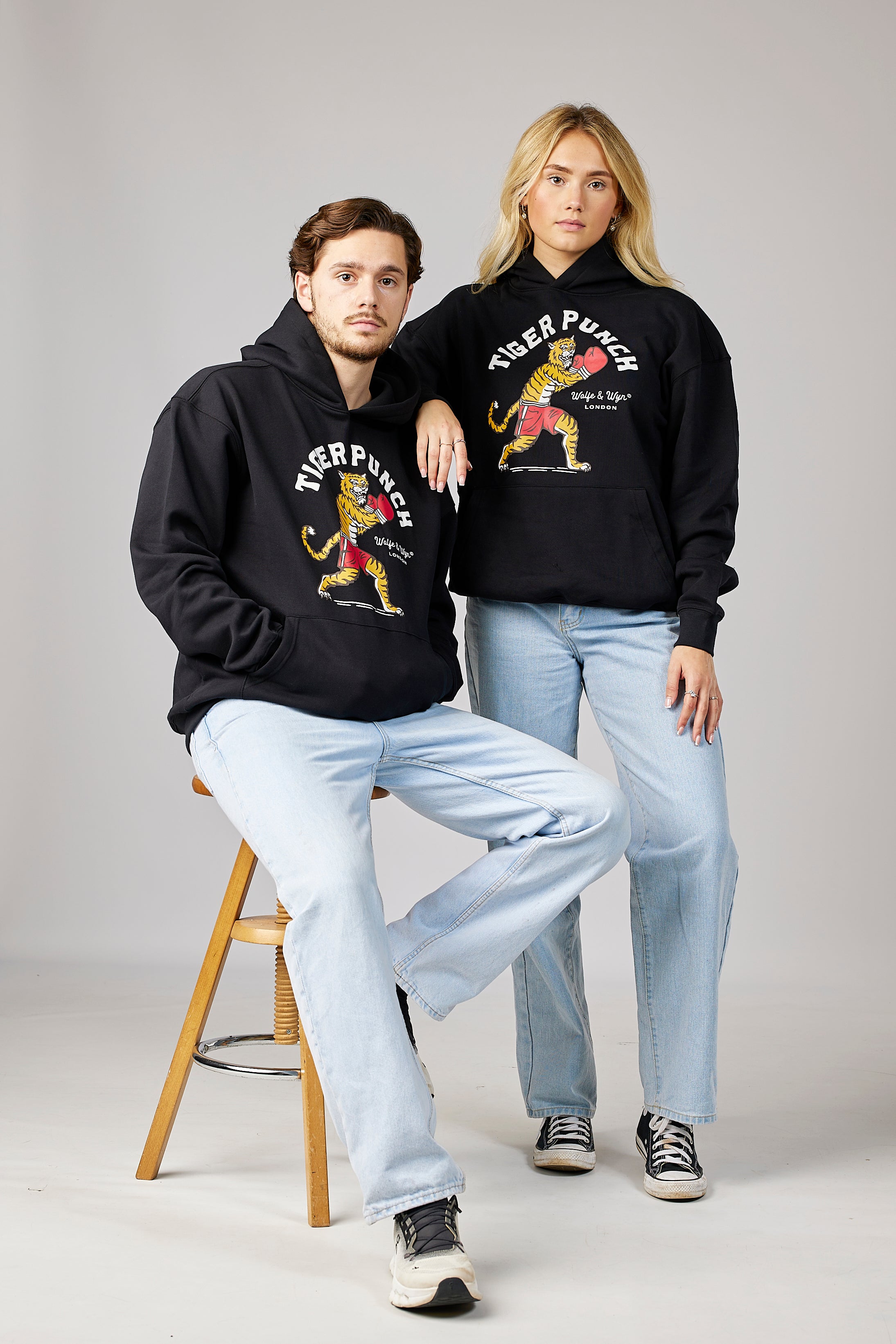 models wearing black hoodies with graphic designs on a gray background