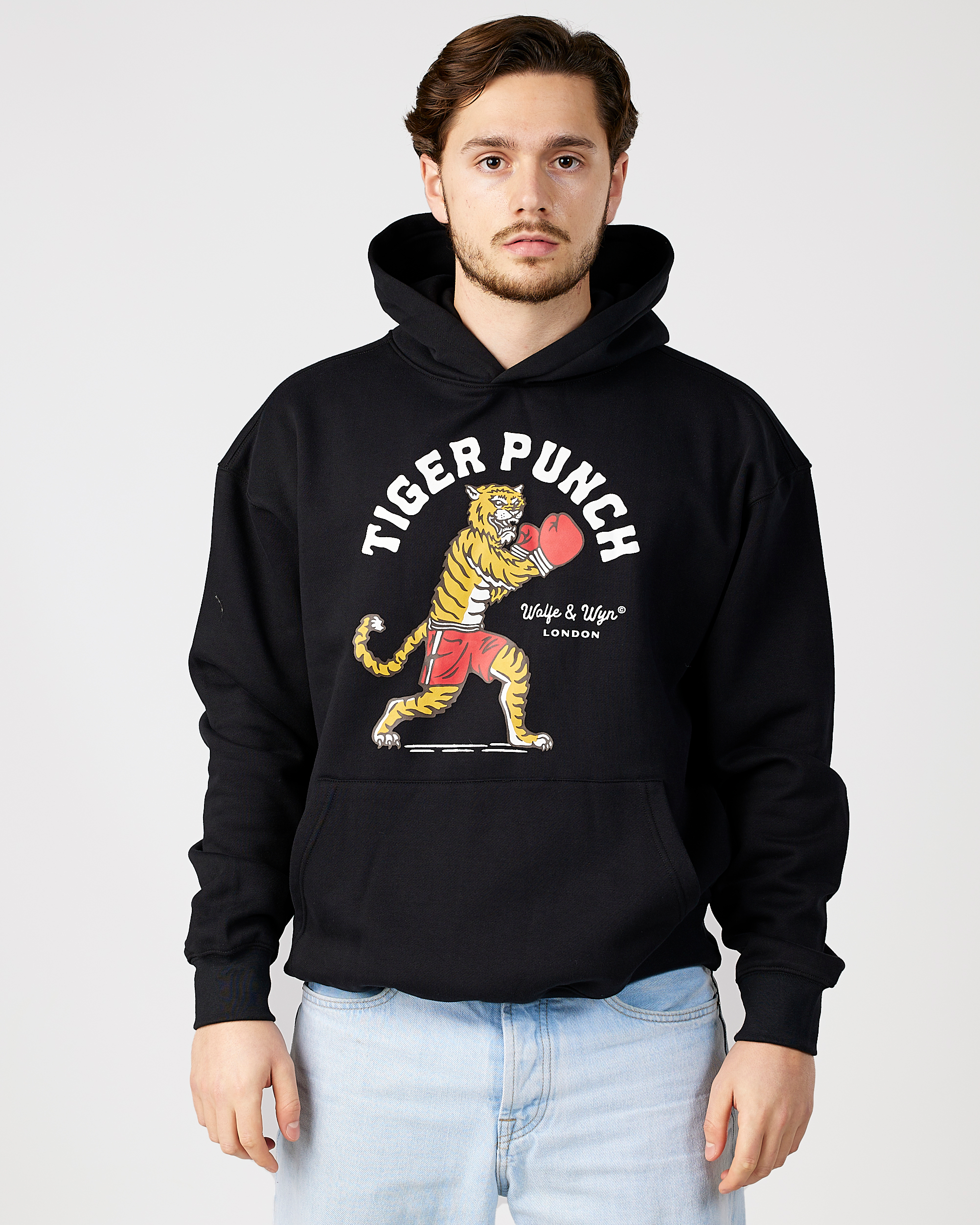 model wearing a black hoodie with a tiger and boxing gloves graphic and 'Tiger Punch' text.