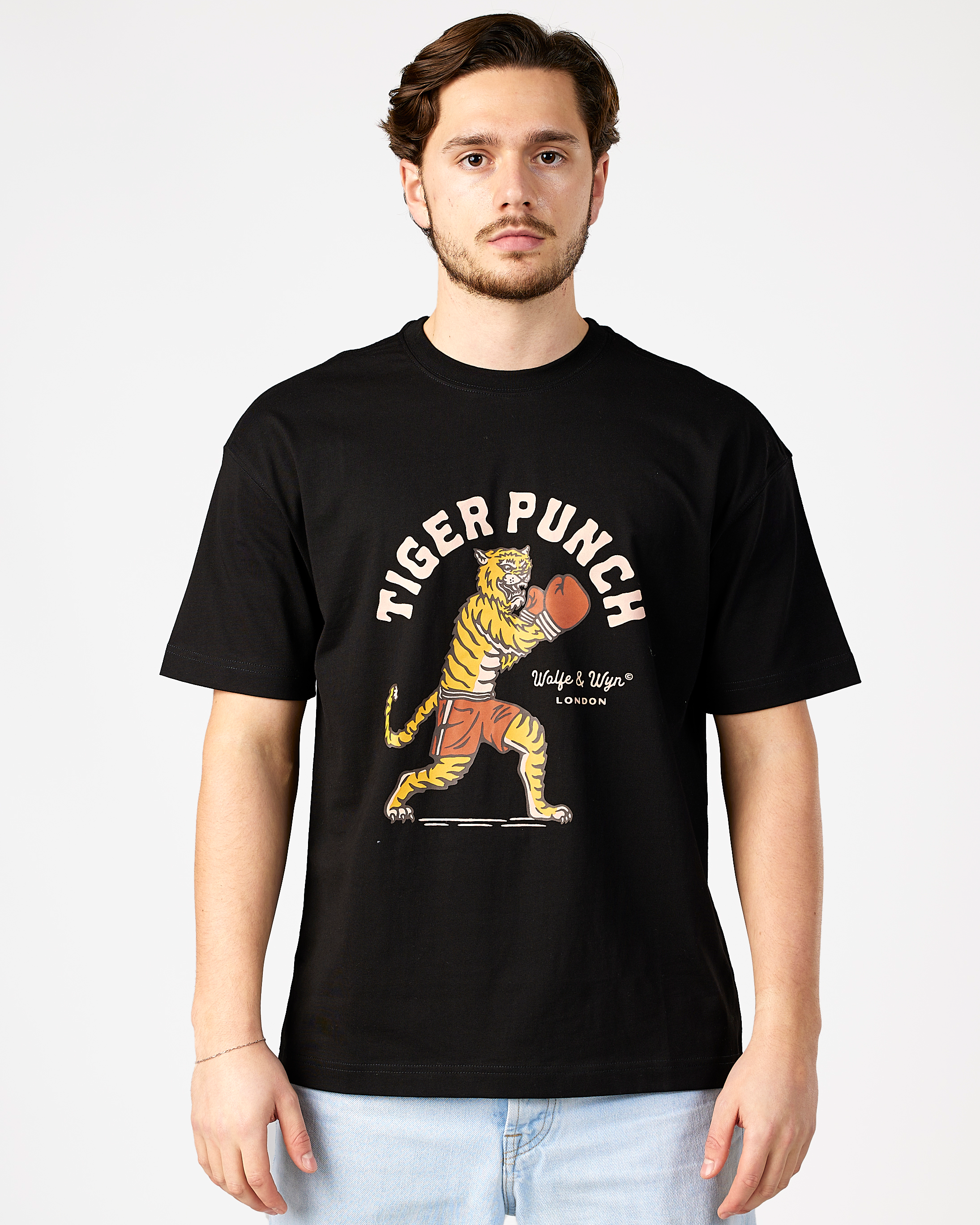 model wearing a black t-shirt with a tiger graphic and text on a white background