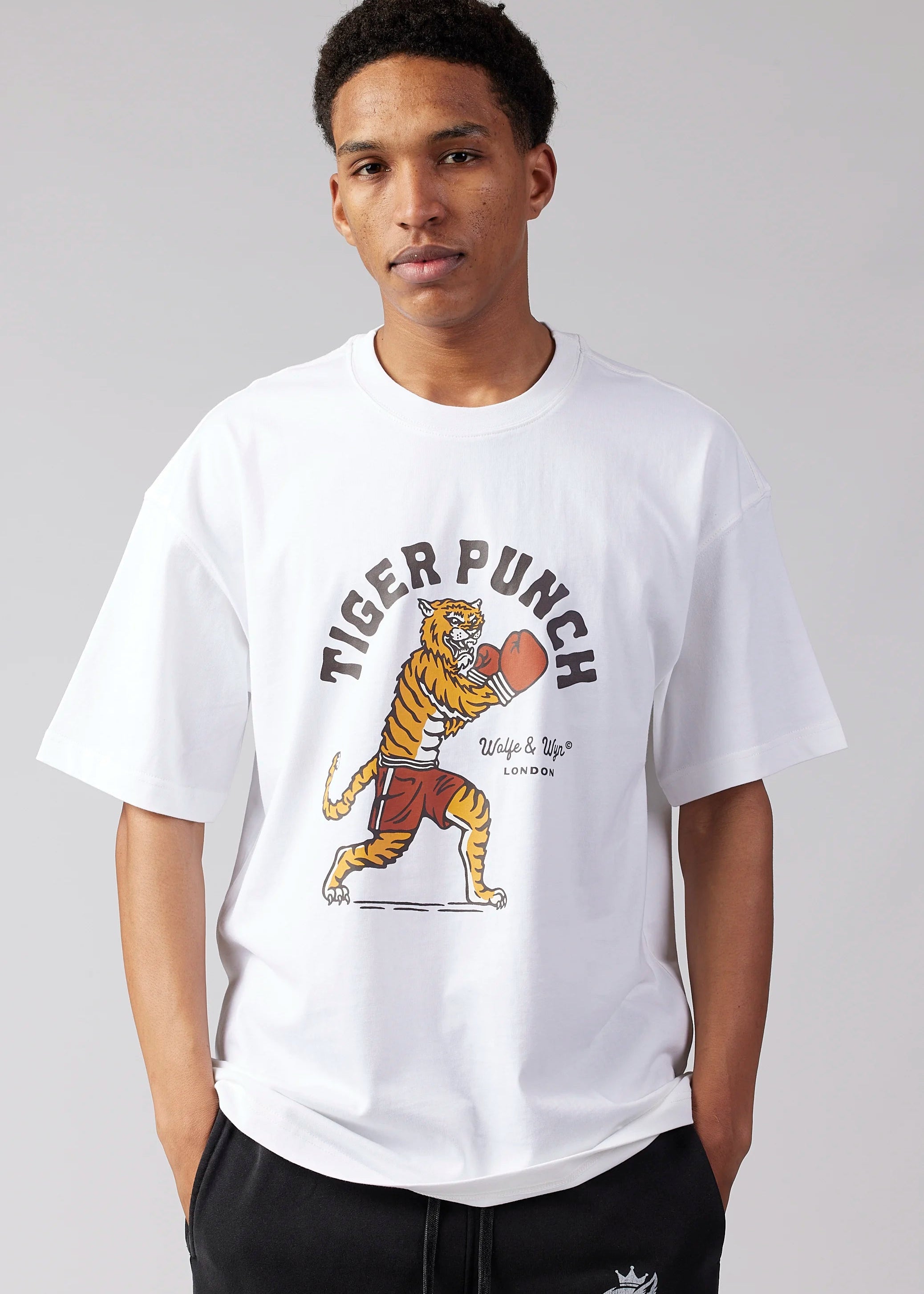 Person wearing a white t-shirt with a tiger graphic and 'Tiger Punch' text on a gray background