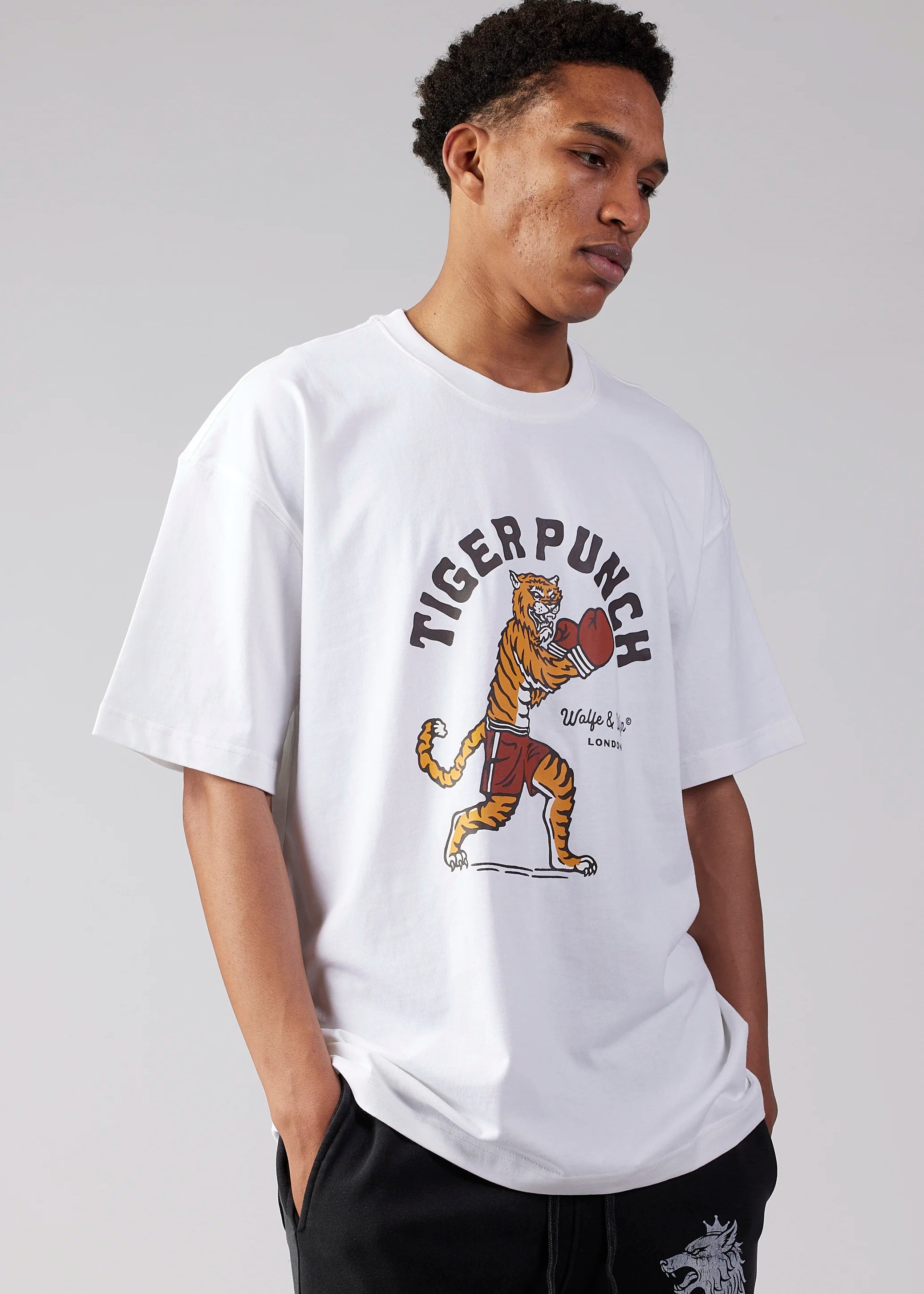 Person wearing a white t-shirt with a tiger graphic and 'Tiger Punch' text on a plain background