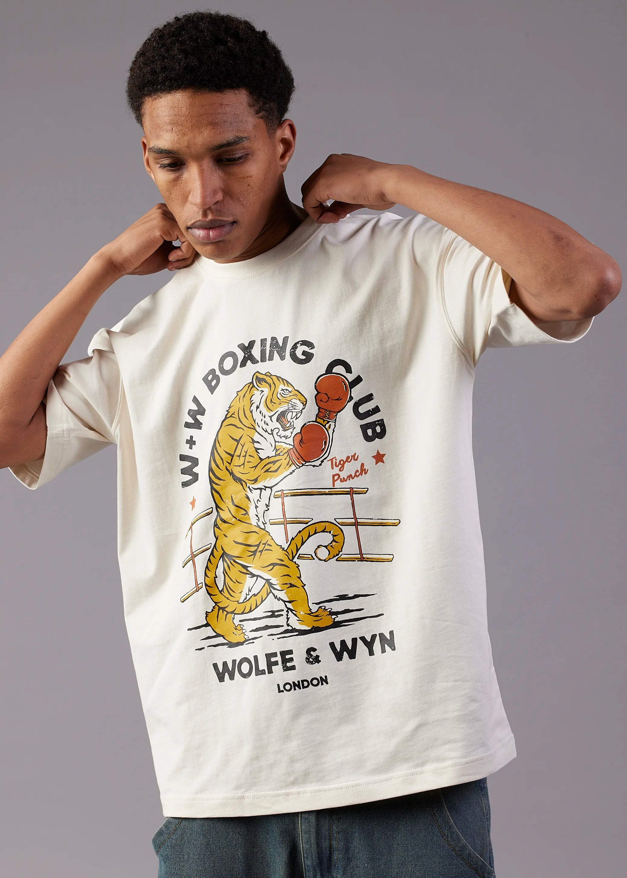 Person wearing a white t-shirt with a boxing-themed graphic and text.