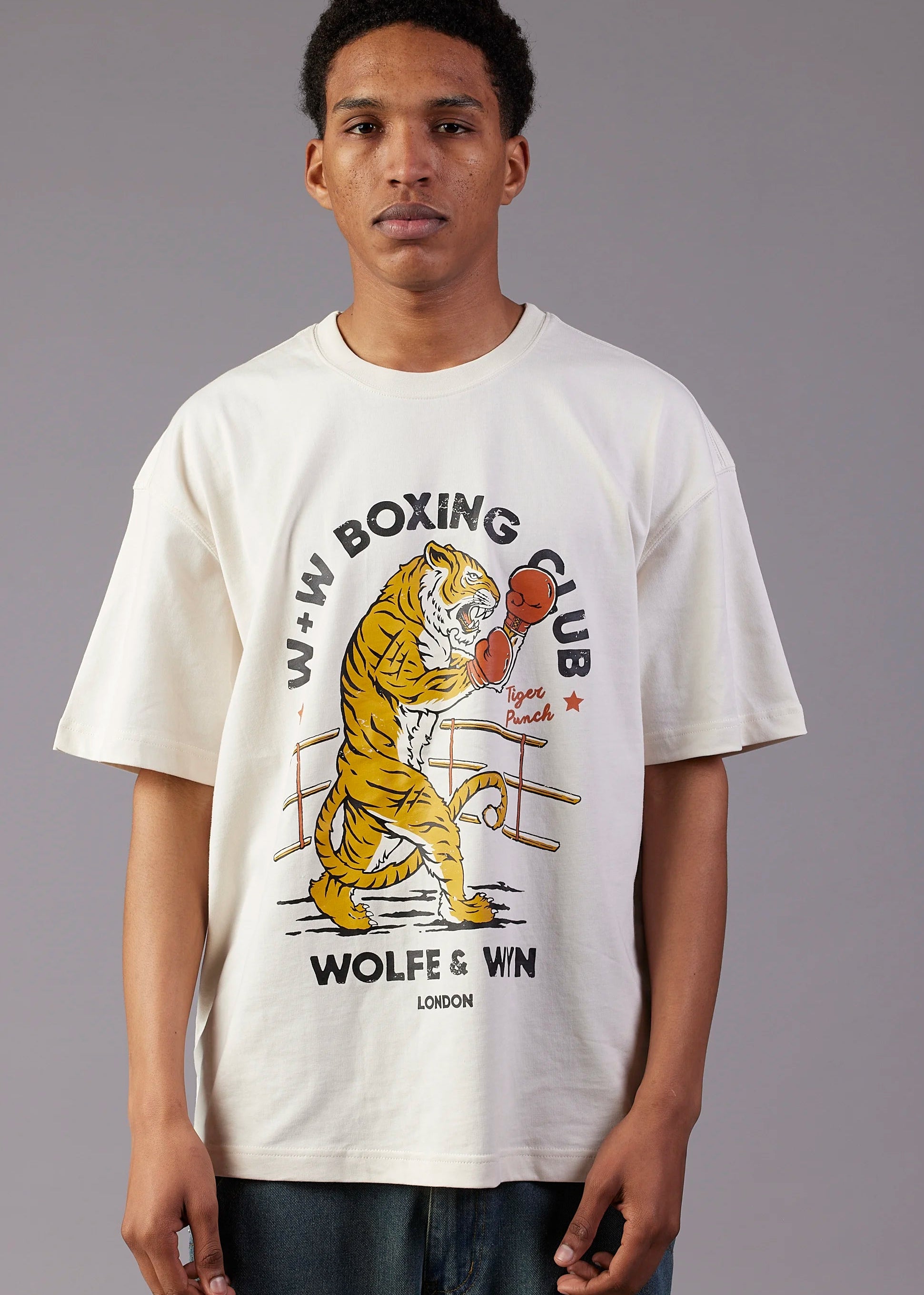 Person wearing a white t-shirt with a boxing tiger graphic and text.
