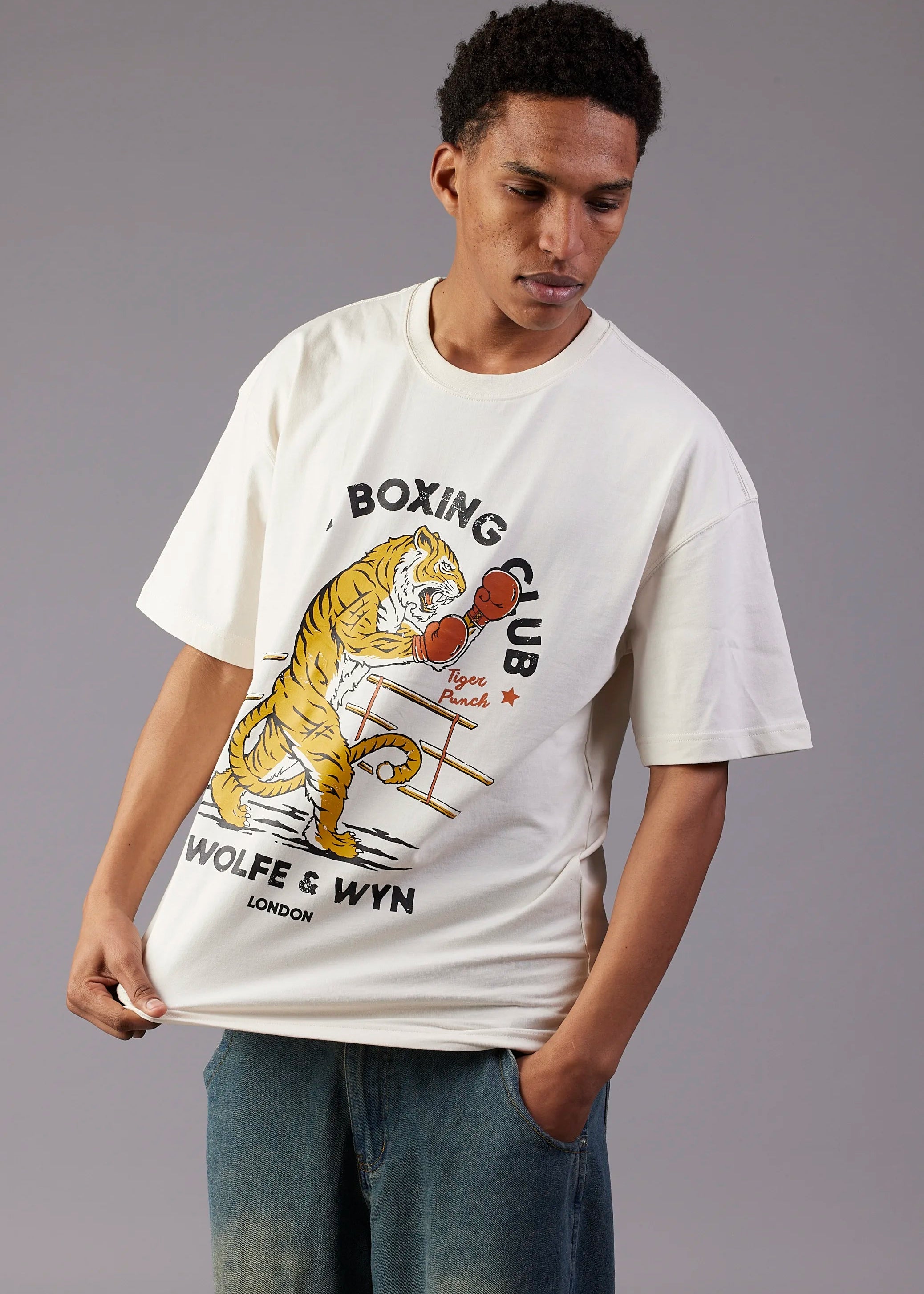 Person wearing a white t-shirt with a tiger graphic and text on a gray background