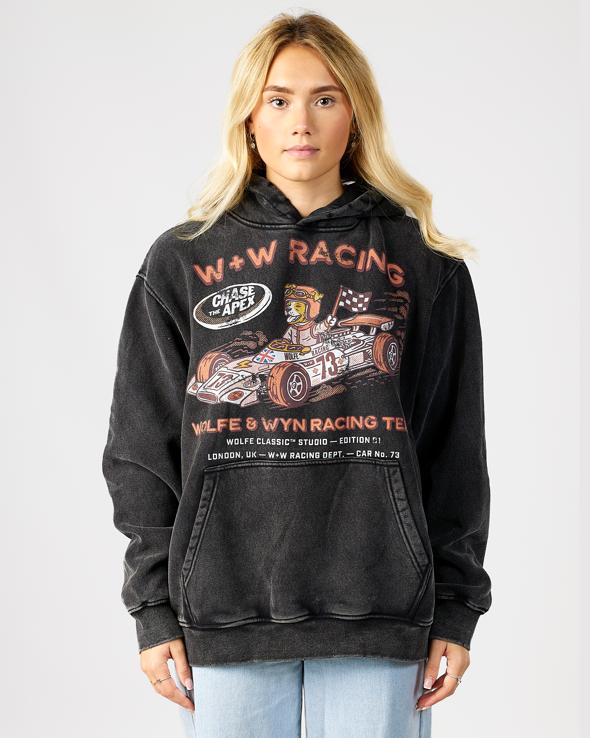 model wearing a black hoodie with racing graphics and text