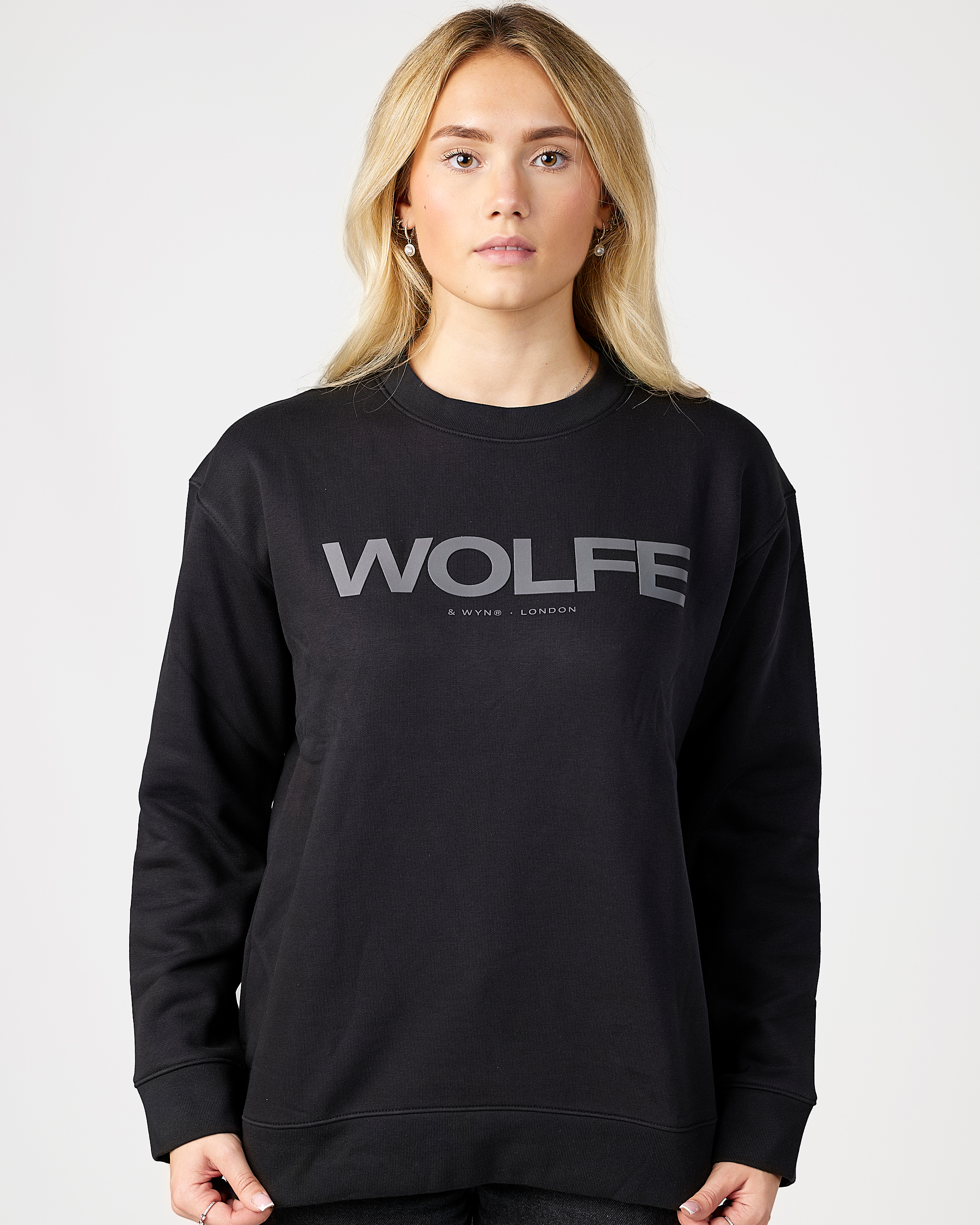Model wearing a black sweatshirt with 'WOLFE' logo on a white background